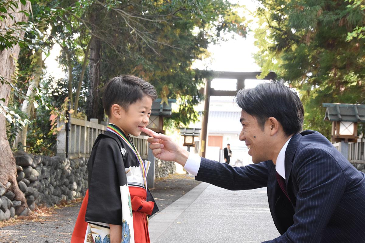 七五三のお参りで触れ合う父親と男の子